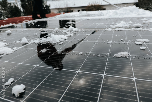  Solar energy shortage in winter. brush clears snow from solar panel. Getting electricity with solar panels in winter.