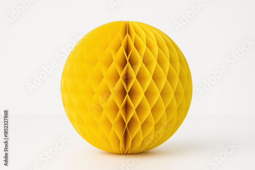 Yellow honeycomb paper ball decoration isolated on white background with geometric folded sphere design