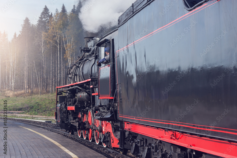 Fototapeta premium Steam train arrives to the platform.