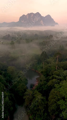 Experience the serene beauty of Khao Sok Thailand as morning mist blankets the lush jungle and revealing majestic mountains. Witness natures tranquility and vibrant greenery come alive at dawn.