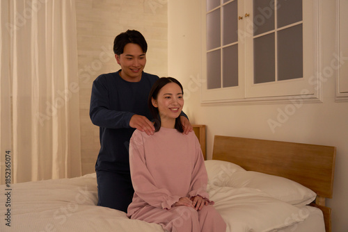 寝室で妻の肩揉みをする夫