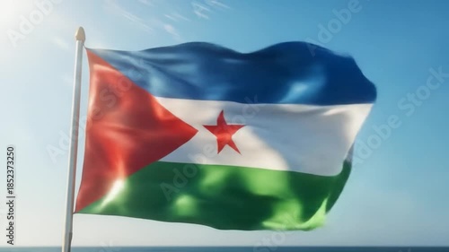 The vibrant djiboutian flag waves gracefully against a serene coastal backdrop, symbolizing