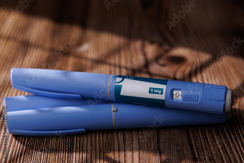 Semaglutide injector pens on a dark wood table at a 45 degree angle view for diabetes care and weight management pharmaceutical stock