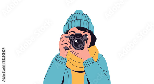 Young woman photographer in winter clothes taking a picture with a camera.