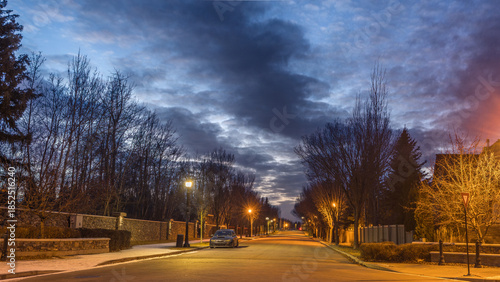 Cityscape with  with street road night lights on and dark cloud in sky