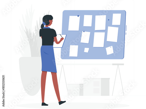 Woman writing on clipboard standing in front of blue bulletin board with blank white notes de