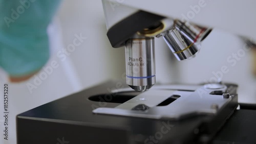 Close up scientist examining samples using optical microscope. High quality 4k footage