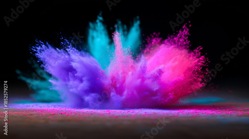 Vibrant explosion of blue and yellow powder captured in midair against a dark background.
