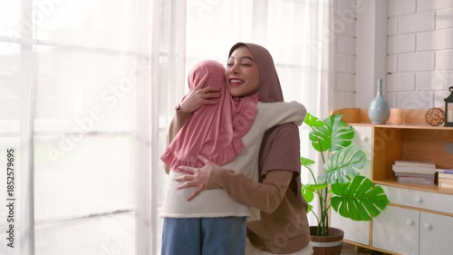 Attractive Muslim family hugging each other in cozy living room at home. 