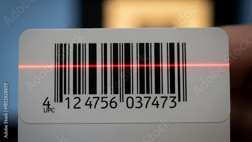 Close-up of a barcode being scanned by a red laser light.