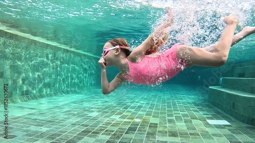 Underwater swimming with children in a pool during midday