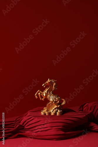 Golden horse statue on red fabric podium. Lunar New Year 2026 symbol