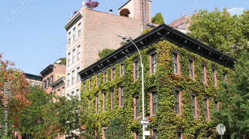 New York City urban residential buildings architecture, Lower Manhattan West village Greenwich street corner, United States of America. Greenwich village, USA. Red brick house. Vine greenery on wall.