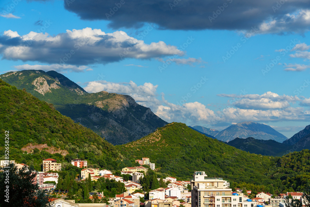 Obraz premium panoramic view of forested mountains and small resort town of Petrovac below, Montenegro, beautiful landscape