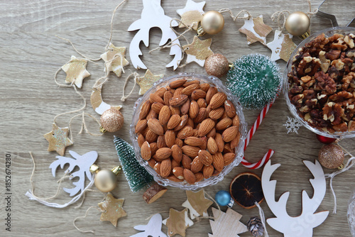 Various Christmas decorations, cookies, chocolate and nuts on wooden background. Flat lay.