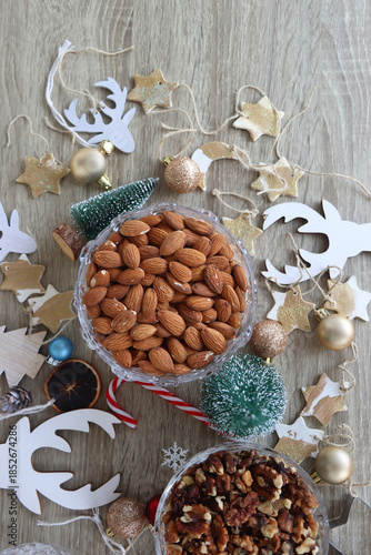 Various Christmas decorations, cookies, chocolate and nuts on wooden background. Flat lay.