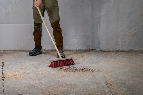 Fotografía Worker sweeping debris during renovation