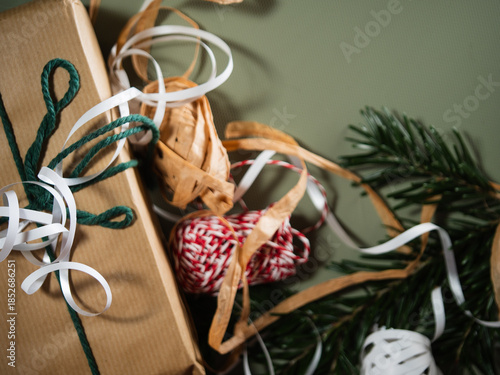 Christmas gift with wrapping ribbon and string green background