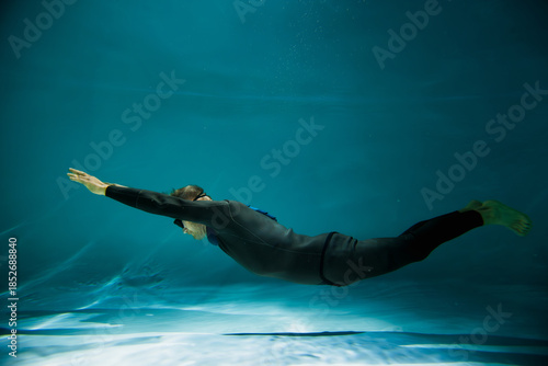 Side view of senior free diver in swimming goggles underwater in pool