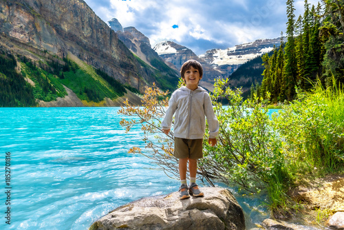 Fotografie Child enjoying breathtaking view of lake louise and surrounding mountains in ban
