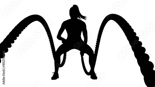 Woman exercising with battle ropes in a fitness studio.