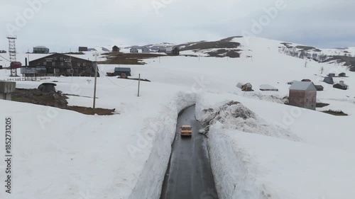 Wallpaper Mural Aerial view of a lone car driving along the Goderdzi pass road with high snow walls, contrasting the dark asphalt with the white snow, Goderdzi, Adjara, Georgia. Torontodigital.ca