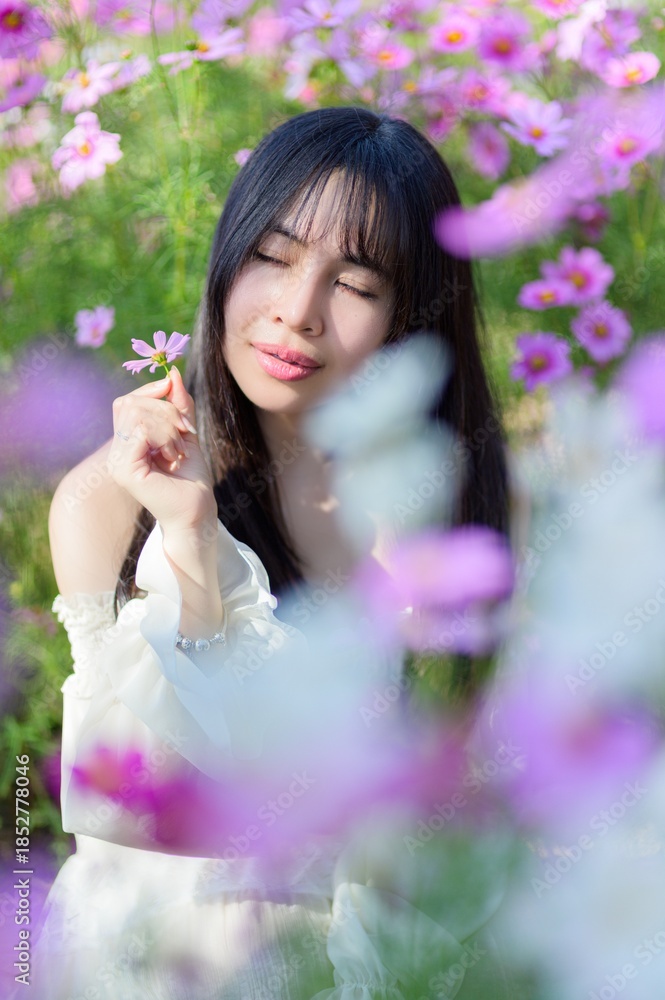 Fototapeta premium Beautiful Woman Smiling with Flowers in a Colorful Spring Field