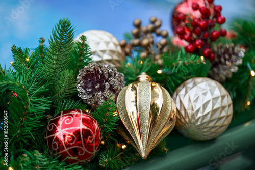 Christmas ornaments and pine cones arranged on greenery.