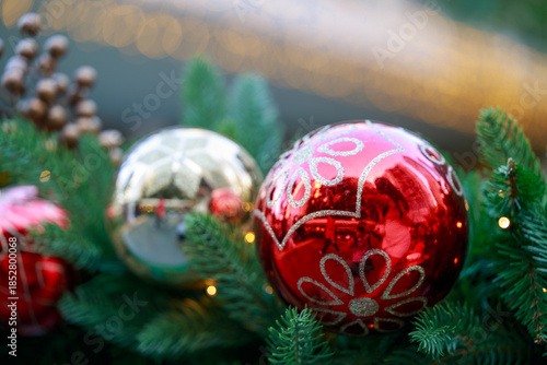 Christmas ornaments and pine cones arranged on greenery.