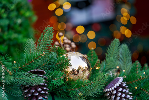 Christmas ornaments and pine cones arranged on greenery.
