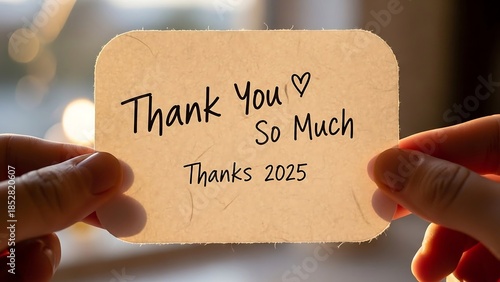 Hands holding a thank you card.