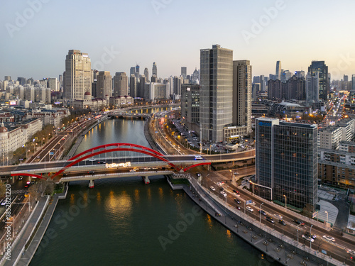 Aerial view of Haihe River snaking through the city, with the eye-catching red arch of Dagu Bridge contrasting against the modern skyline, Tianjin, Tianjin, China.