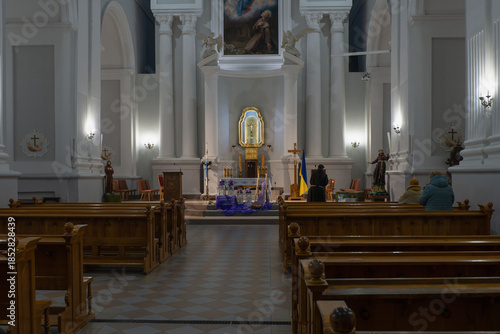 The church's formal interior with an altar and benches, decorated with the Ukrainian flag.