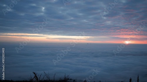 sunset over clouds/clouds under the mountains