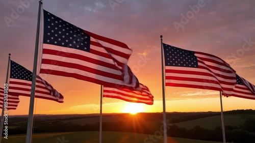 Multiple american flags flying at sunset over rolling hills