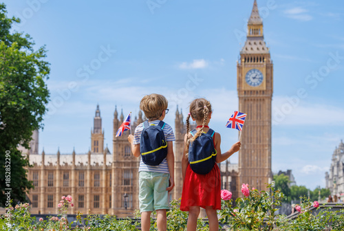 Photography Two kids, with UK flags gaze at Big Ben on summer trip in London
