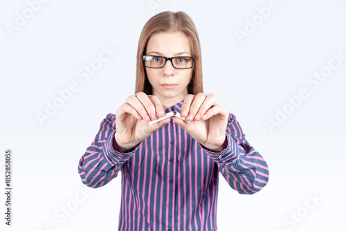 фотографія Young girl breaking cigarette, no smoking concept
