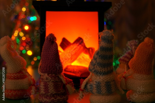 Toy angels warming themselves by the fireplace