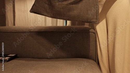 Closeup video of young woman adjusting the pillows on the couch. Cosy evening at home. Comfortable and modern interior design. Fluffing and beating the pillows.