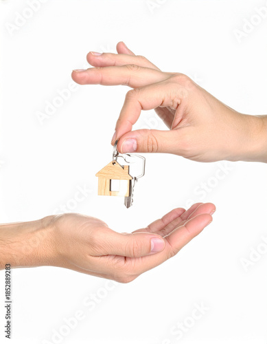 A professional real estate agent's hand giving new house keys to people for a successful property sale or mortgage business concept
