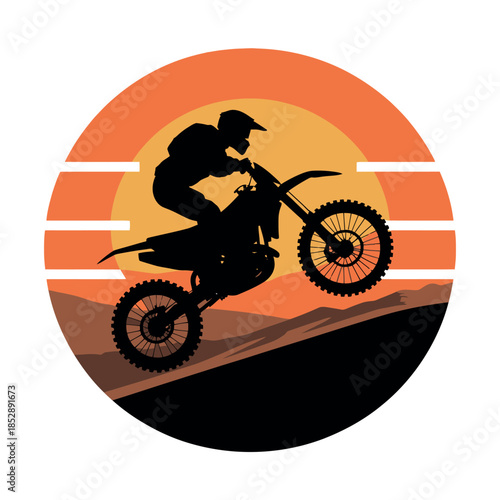A silhouetted motocross rider performs a wheelie against a sunset background.
