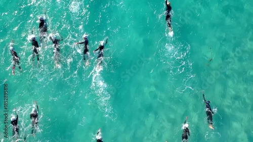 Aerial photo of a swimmers in open water swimming competition in turquoise sea