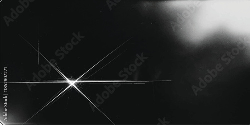 A bright starburst effect illuminates a dark, abstract background in black and white