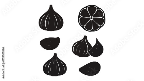 A collection of black garlic and lemon slices on a white background.