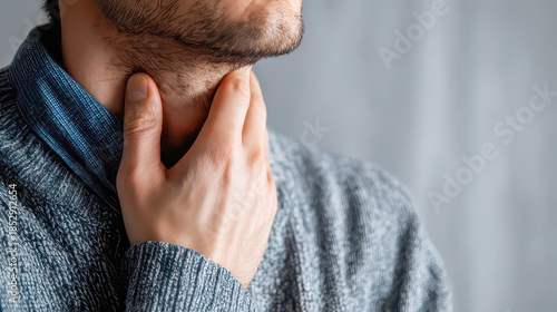 Man suffering from sore throat touching neck with hand