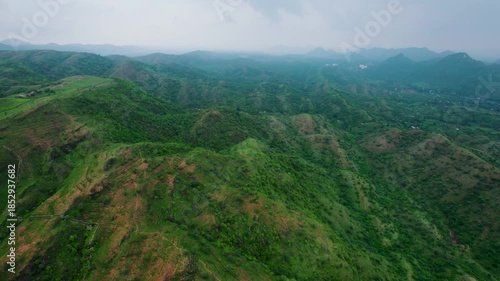 4K aerial view of Rayta Hills at Udaipur, Rajasthan, India. Green mountains and cloudy sky during monsoon season. Travel and holidays background. Lush green hills of Aravalli Range. Protect ecology co