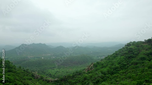 Rayta hills in Aravalli mountain range of Udaipur, Rajasthan, India. 4K Aerial view of a lush green hills of Aravalli Range. Dark clouds in sky during monsoon season.