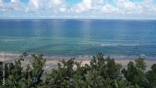 Breathtaking aerial panorama of Lang Co features a pristine sandy coastline, turquoise ocean, red-roofed resorts, and majestic green mountains.