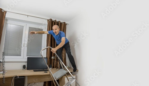 Senior citizen fixing curtain rod. Pensioner standing on the desk. Home accident