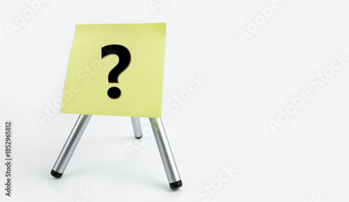 Yellow note paper on a Tripod with a question mark. Asking questions, searching for truth. Curiosity, learn and improve. mystery, investigation research. Poll Survey